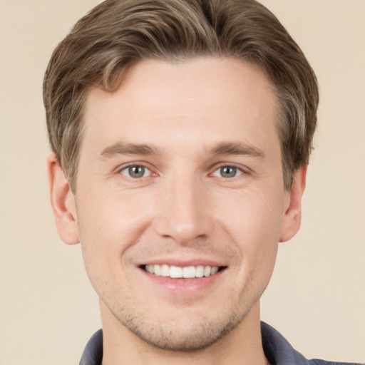 Joyful white young-adult male with short  brown hair and grey eyes