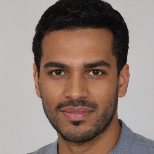 Joyful latino young-adult male with short  black hair and brown eyes