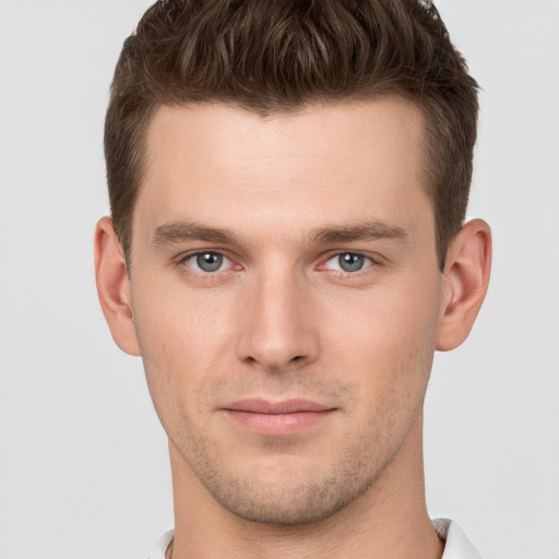 Joyful white young-adult male with short  brown hair and grey eyes