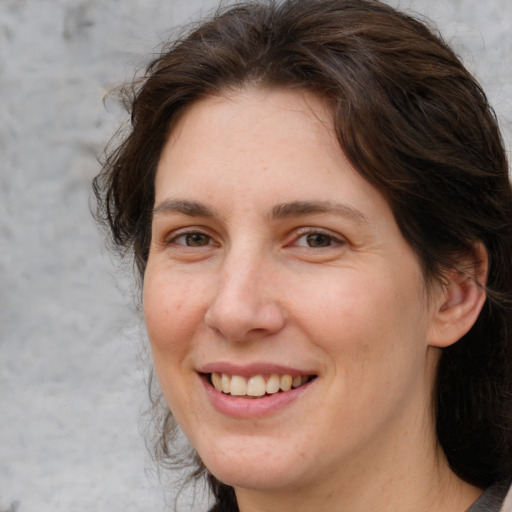 Joyful white adult female with medium  brown hair and brown eyes