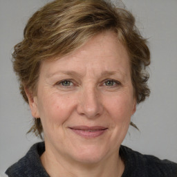 Joyful white adult female with medium  brown hair and blue eyes