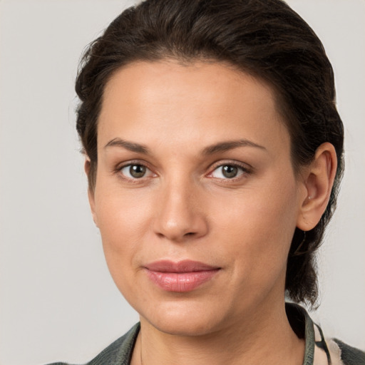 Joyful white young-adult female with medium  brown hair and grey eyes