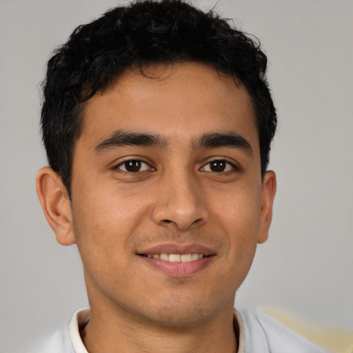 Joyful latino young-adult male with short  brown hair and brown eyes