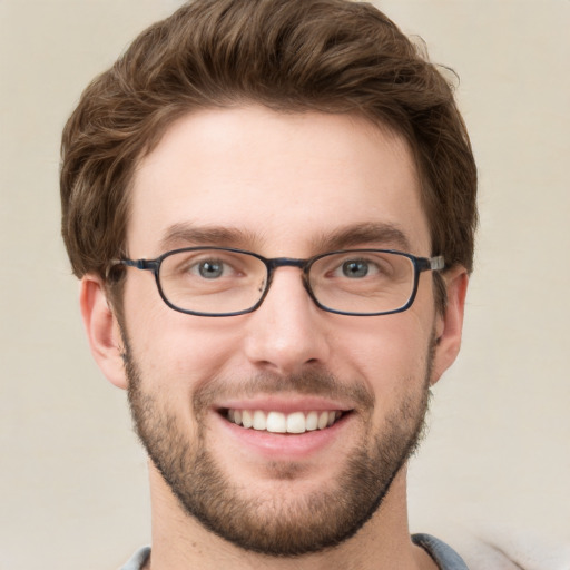 Joyful white young-adult male with short  brown hair and grey eyes