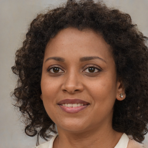 Joyful black young-adult female with medium  brown hair and brown eyes