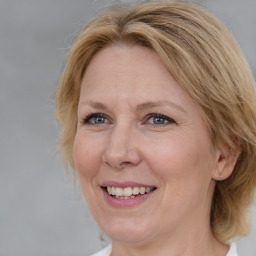 Joyful white adult female with medium  brown hair and blue eyes