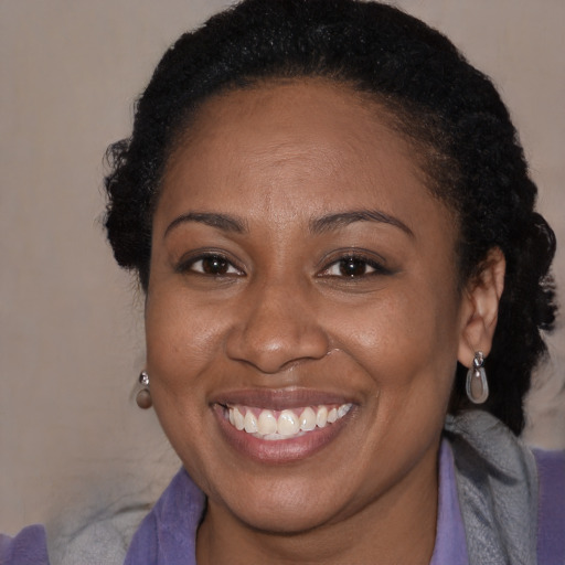 Joyful black adult female with medium  brown hair and brown eyes