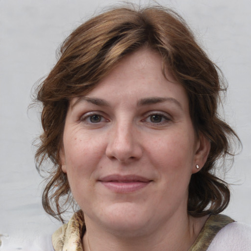 Joyful white adult female with medium  brown hair and grey eyes