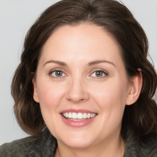 Joyful white young-adult female with medium  brown hair and grey eyes