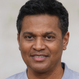 Joyful black adult male with short  black hair and brown eyes