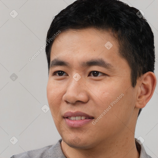 Joyful asian young-adult male with short  black hair and brown eyes