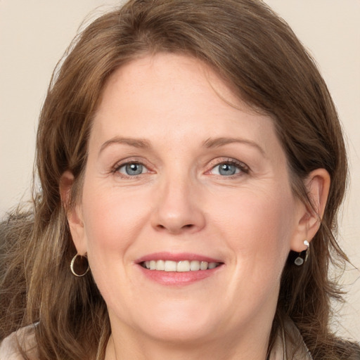 Joyful white adult female with long  brown hair and grey eyes