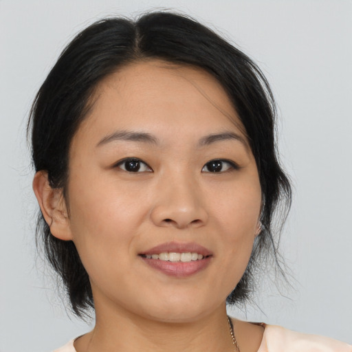 Joyful asian young-adult female with medium  brown hair and brown eyes