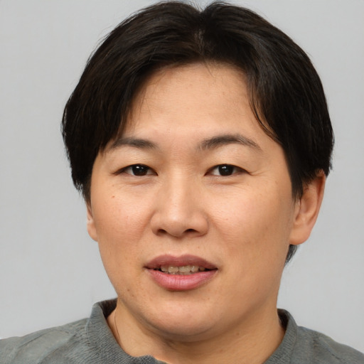 Joyful asian adult female with short  brown hair and brown eyes