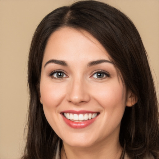 Joyful white young-adult female with long  brown hair and brown eyes