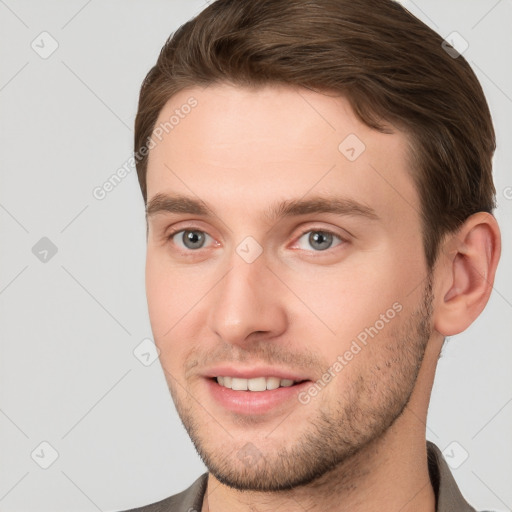 Joyful white young-adult male with short  brown hair and grey eyes