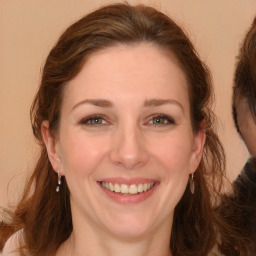 Joyful white young-adult female with long  brown hair and grey eyes