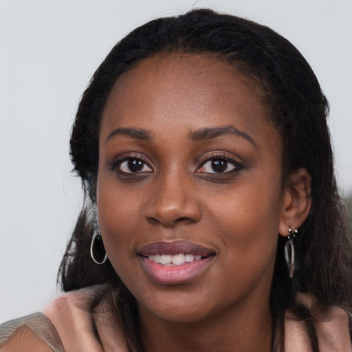 Joyful black young-adult female with long  black hair and brown eyes
