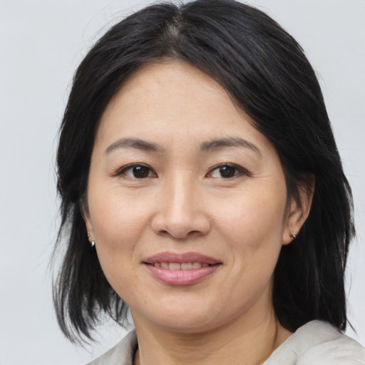 Joyful asian adult female with medium  brown hair and brown eyes