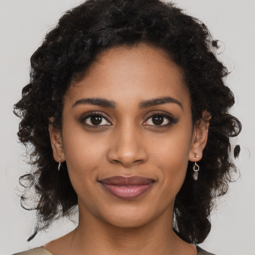 Joyful black young-adult female with long  brown hair and brown eyes