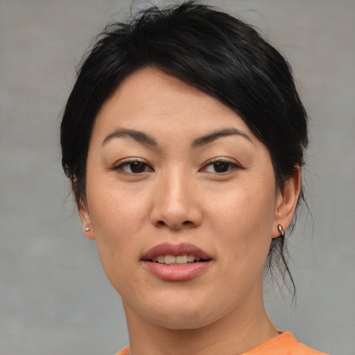 Joyful asian young-adult female with medium  black hair and brown eyes