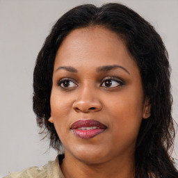 Joyful black young-adult female with long  brown hair and brown eyes