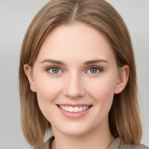 Joyful white young-adult female with medium  brown hair and grey eyes