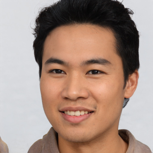 Joyful asian young-adult male with short  black hair and brown eyes