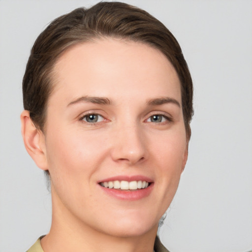 Joyful white young-adult female with short  brown hair and grey eyes