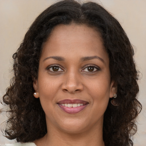 Joyful black young-adult female with long  brown hair and brown eyes