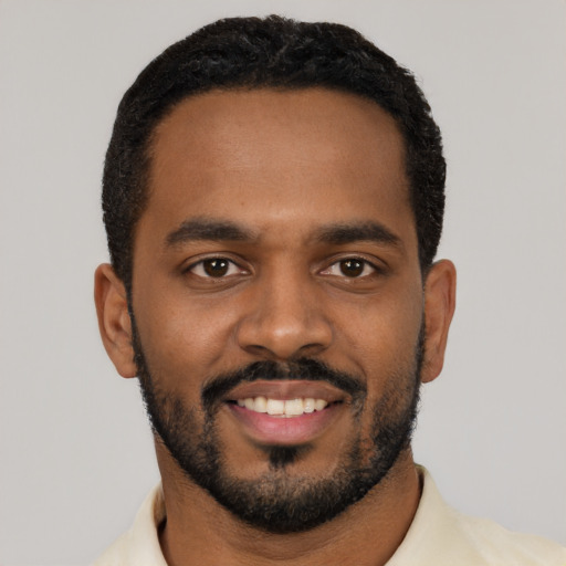 Joyful black young-adult male with short  black hair and brown eyes