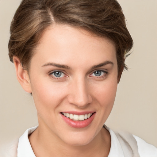 Joyful white young-adult female with short  brown hair and grey eyes