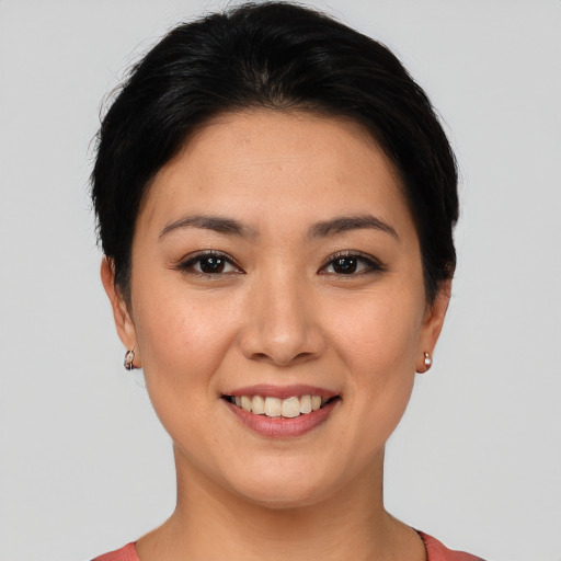 Joyful asian young-adult female with short  brown hair and brown eyes
