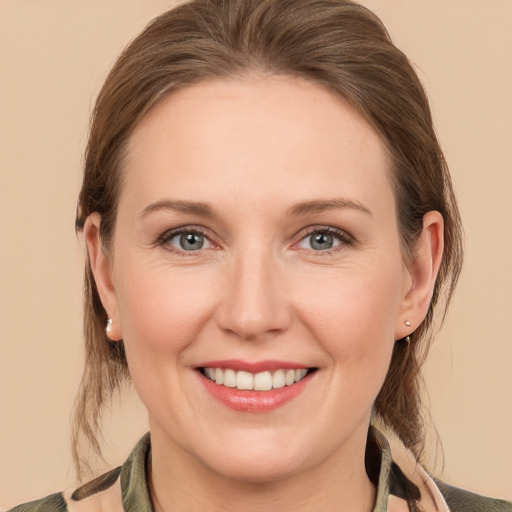 Joyful white young-adult female with medium  brown hair and grey eyes