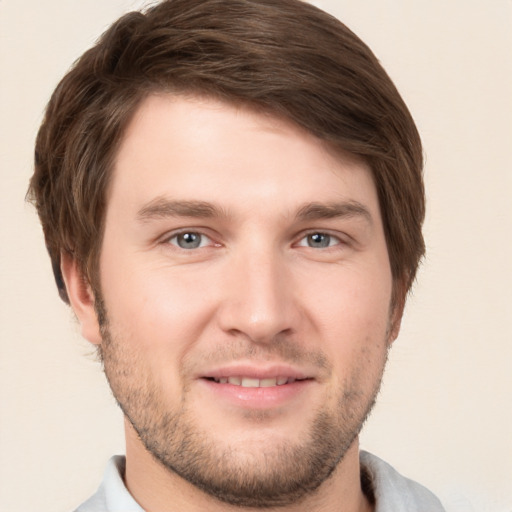 Joyful white young-adult male with short  brown hair and grey eyes