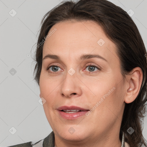 Joyful white adult female with medium  brown hair and grey eyes