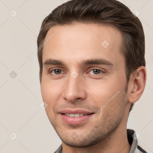 Joyful white young-adult male with short  brown hair and brown eyes