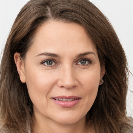 Joyful white adult female with long  brown hair and brown eyes