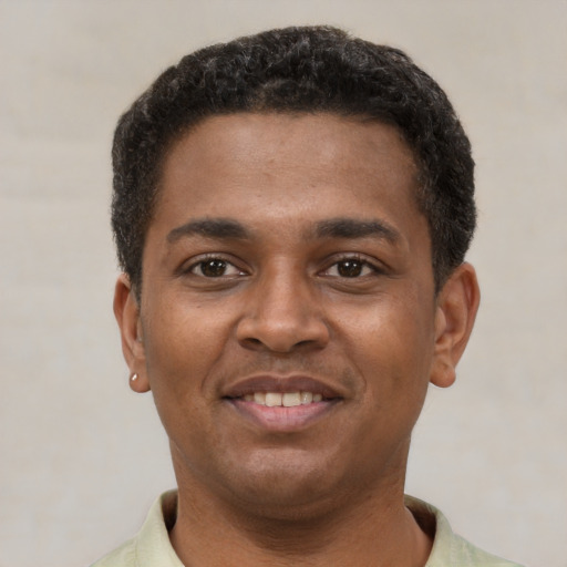 Joyful latino young-adult male with short  black hair and brown eyes