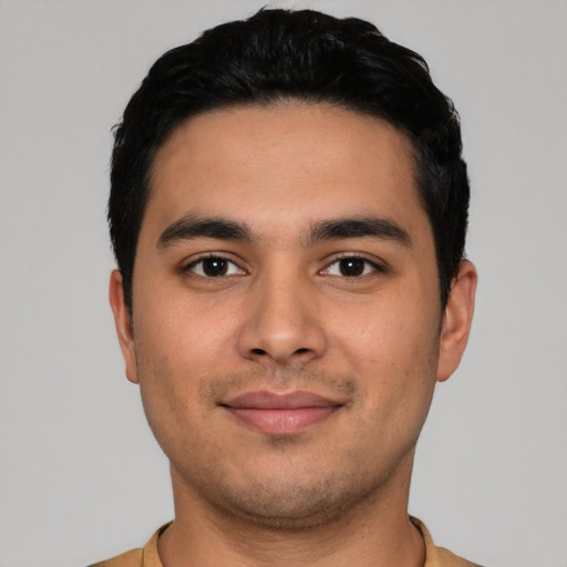 Joyful latino young-adult male with short  black hair and brown eyes