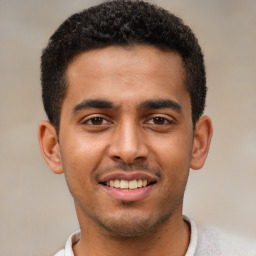 Joyful latino young-adult male with short  black hair and brown eyes