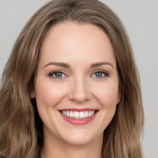 Joyful white young-adult female with long  brown hair and green eyes