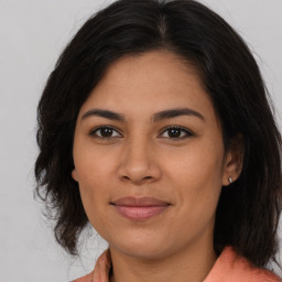 Joyful latino young-adult female with medium  brown hair and brown eyes