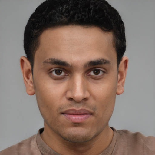 Joyful latino young-adult male with short  brown hair and brown eyes