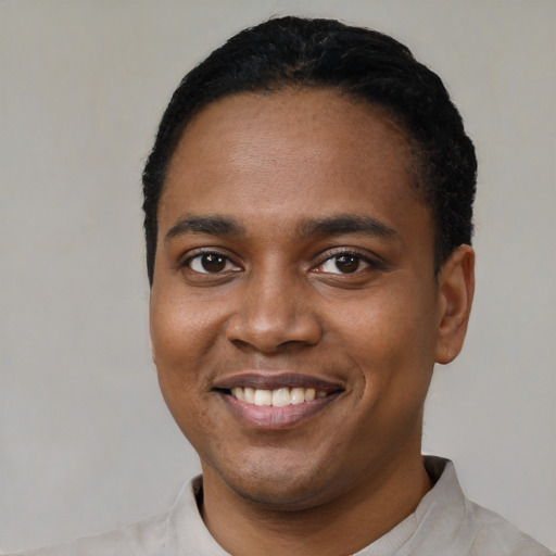 Joyful black young-adult male with short  black hair and brown eyes