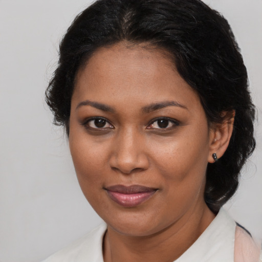 Joyful black young-adult female with long  brown hair and brown eyes