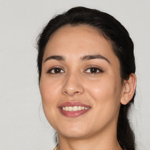 Joyful latino young-adult female with long  black hair and brown eyes
