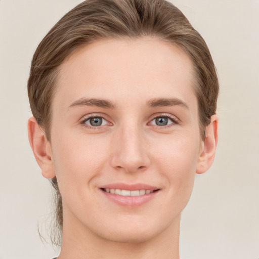 Joyful white young-adult female with short  brown hair and grey eyes