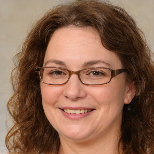 Joyful white adult female with medium  brown hair and green eyes