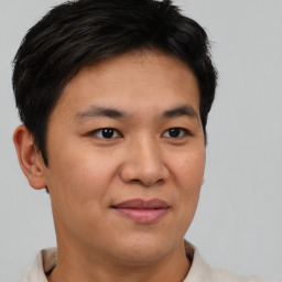 Joyful asian young-adult male with short  brown hair and brown eyes